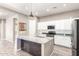 Island kitchen with stainless appliances, granite island, white cabinets and a undermounted microwave at 3023 E Arabian Dr, Gilbert, AZ 85296