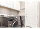 Laundry room with modern front-load washer and dryer and white cabinets for storage at 3023 E Arabian Dr, Gilbert, AZ 85296