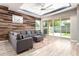 Stylish living room with a modern sectional, wood accent wall, recessed lighting, and glass doors to the backyard at 3023 E Arabian Dr, Gilbert, AZ 85296