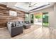 Cozy living room with modern decor, a sectional sofa, decorative wood wall, and sliding glass doors to the backyard at 3023 E Arabian Dr, Gilbert, AZ 85296
