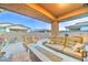 Covered patio with comfortable outdoor seating, fire pit, landscaped yard, and paver flooring at 3153 E Ivanhoe St, Gilbert, AZ 85295