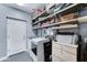 Spacious laundry room features a washer, dryer, shelving for storage, and tile floors at 3153 E Ivanhoe St, Gilbert, AZ 85295