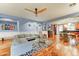 Bright living room featuring a comfortable gray sofa, decorative ceiling fan, and light blue painted walls at 3153 E Ivanhoe St, Gilbert, AZ 85295
