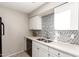 Well-lit kitchen featuring white cabinets, stainless steel sink, stylish backsplash and modern appliances at 317 W Tonopah Dr # 2, Phoenix, AZ 85027