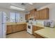 An open kitchen area boasts a large window, laminate countertops, and warm wood cabinetry at 3345 E University Dr # 73, Mesa, AZ 85213