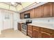 Kitchen features wooden cabinetry, black appliances, and tile flooring at 3345 E University Dr # 73, Mesa, AZ 85213
