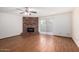 Spacious living room featuring a brick fireplace, wood flooring, and sliding glass doors at 3345 E University Dr # 73, Mesa, AZ 85213