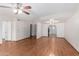A bright living room featuring wood flooring, two ceiling fans, and white walls at 3345 E University Dr # 73, Mesa, AZ 85213