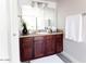 Bathroom vanity with granite countertops, dark wood cabinets, decorative mirror, and gray tile flooring at 3500 N Hayden Rd # 2103, Scottsdale, AZ 85251