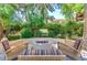 Inviting firepit area with comfortable seating, surrounded by lush greenery and mature trees at 3500 N Hayden Rd # 2103, Scottsdale, AZ 85251