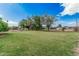 Expansive green backyard with mature trees and grass is perfect for entertaining at 370 E Redfield Rd, Chandler, AZ 85225