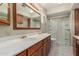 This bathroom features a dual sink vanity with wood cabinets and a glass enclosed shower at 370 E Redfield Rd, Chandler, AZ 85225