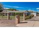 Wide view of home featuring a black iron gate, brick columns, lush lawn, and well-maintained landscape at 370 E Redfield Rd, Chandler, AZ 85225