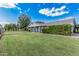 Expansive home with a large lawn, blue siding, brick accents, and mature trees offering privacy at 370 E Redfield Rd, Chandler, AZ 85225