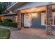 Inviting front porch with brick columns, a white door, and charming exterior lighting at dusk at 370 E Redfield Rd, Chandler, AZ 85225