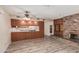 Living room showing the brick fireplace, wood-look floors and access to the kitchen area at 370 E Redfield Rd, Chandler, AZ 85225
