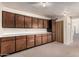 Room featuring neutral walls, carpeted floors, upper and lower wood cabinets, and counter space at 370 E Redfield Rd, Chandler, AZ 85225