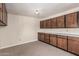 Room featuring neutral walls, carpeted floors, upper and lower wood cabinets, and counter space at 370 E Redfield Rd, Chandler, AZ 85225