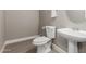 Bathroom with a white toilet, sink, and a round mirror at 4002 E Melinda Ln, Phoenix, AZ 85050