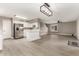 Open floor plan with white kitchen, stainless steel appliances, and a modern light fixture at 4002 E Melinda Ln, Phoenix, AZ 85050