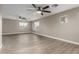 Spacious living room with light wood floors, neutral walls, large windows, and ceiling fans at 4002 E Melinda Ln, Phoenix, AZ 85050