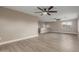 Bright living room features light wood floors, neutral walls, large windows, and two modern ceiling fans at 4002 E Melinda Ln, Phoenix, AZ 85050