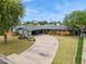 A charming single-story brick home featuring a circular driveway, mature trees, and lush green lawns at 4408 N 28Th Pl, Phoenix, AZ 85016