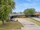 A charming single-story brick home featuring a circular driveway, mature trees, and lush green lawns at 4408 N 28Th Pl, Phoenix, AZ 85016
