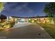 Charming single story brick home with a circular driveway and attached carport at twilight at 4408 N 28Th Pl, Phoenix, AZ 85016