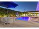Backyard pool area with manicured hedges, an umbrella, and ambient lighting at 4408 N 28Th Pl, Phoenix, AZ 85016