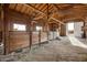 A horse barn offers stalls with wooden dividers and a dirt floor covered in hay at 447 W Judd Rd, San Tan Valley, AZ 85143