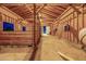 Spacious barn interior featuring wood beams, stalls, and ample natural light at 447 W Judd Rd, San Tan Valley, AZ 85143