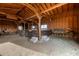 A horse barn offers stalls with wooden dividers, concrete steps, and a dirt floor covered in hay at 447 W Judd Rd, San Tan Valley, AZ 85143