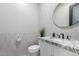 Stylish half-bathroom features modern fixtures, a round mirror, and sleek tile work at 447 W Judd Rd, San Tan Valley, AZ 85143