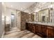 Dual vanity bathroom with brick accents, granite countertops, and wood-look flooring at 447 W Judd Rd, San Tan Valley, AZ 85143