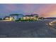 A custom home featuring stunning exterior design with circular driveway, turf, and beautiful lighting at dusk at 447 W Judd Rd, San Tan Valley, AZ 85143
