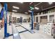 Well-lit garage featuring a car lift, work area, and ample storage for automotive projects and organization at 447 W Judd Rd, San Tan Valley, AZ 85143