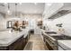 A modern kitchen featuring stainless steel appliances, a farmhouse sink, dark cabinets, and marble countertops at 447 W Judd Rd, San Tan Valley, AZ 85143
