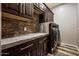 Laundry room features a brick accent wall, wooden cabinets and drawers with silver hardware and a granite countertop at 447 W Judd Rd, San Tan Valley, AZ 85143