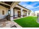 Expansive covered patio with comfortable seating and ceiling fans overlooking a well-manicured backyard at 447 W Judd Rd, San Tan Valley, AZ 85143