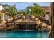 Resort-style pool with a majestic rock waterfall and lush tropical landscaping at 447 W Judd Rd, San Tan Valley, AZ 85143
