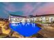 Backyard pool featuring a stone waterfall, integrated lighting, and stylish outdoor seating areas at 447 W Judd Rd, San Tan Valley, AZ 85143