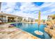 Resort style pool with rock waterfall and umbrellas to provide shade on a sunny day at 447 W Judd Rd, San Tan Valley, AZ 85143