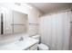 Well-lit bathroom with a large mirror, sink, toilet, and shower with curtain at 4502 E Carol Ave # 1, Mesa, AZ 85206