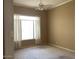 Bright bedroom with a ceiling fan and a large window adorned with white curtains at 4843 E Estevan Rd, Phoenix, AZ 85054