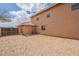 Back exterior of house featuring yellow-toned siding, rock landscaping and fencing at 504 E Racine Pl, Casa Grande, AZ 85122