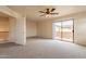Bright living room featuring a ceiling fan, sliding door, and neutral carpet at 504 E Racine Pl, Casa Grande, AZ 85122