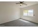 This bedroom has gray carpet, a ceiling fan and bright natural light at 507 W Magdalena Ln, Phoenix, AZ 85041
