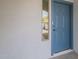 Inviting front entry featuring a stylish blue door with modern hardware and textured white walls at 507 W Magdalena Ln, Phoenix, AZ 85041