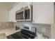 Close up view of the stainless steel microwave and electric range with white cabinets in the kitchen at 507 W Magdalena Ln, Phoenix, AZ 85041